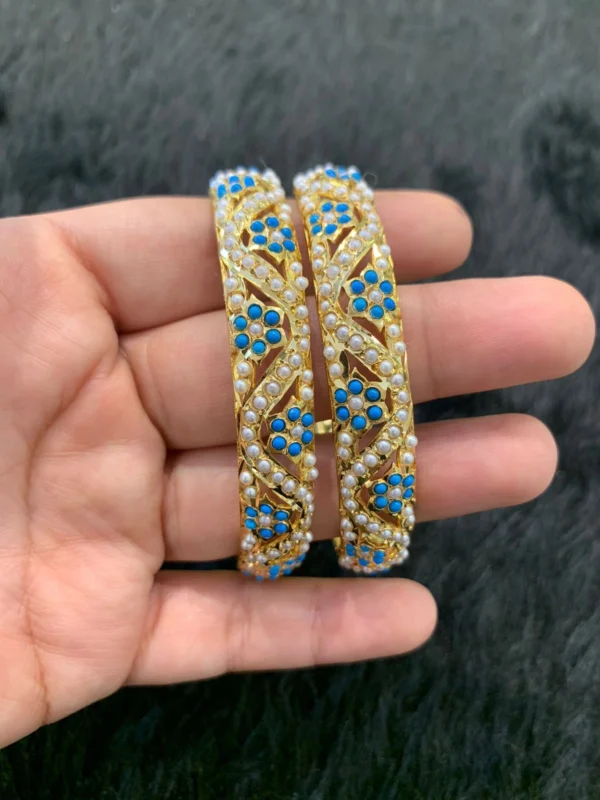 A close-up of handcrafted Solid Turquoise Bangles with kundan work and gold polish