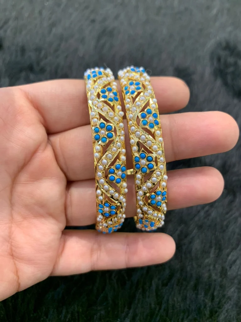 A close-up of handcrafted Solid Turquoise Bangles with kundan work and gold polish