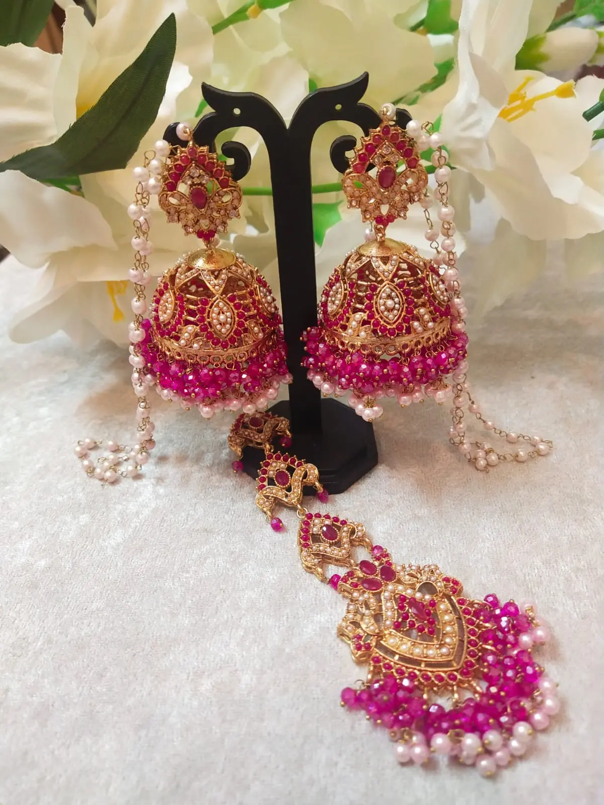 Pink Jhumka with Tikka Set featuring Hyderabadi jadau work and semi-precious pink and white stones.
